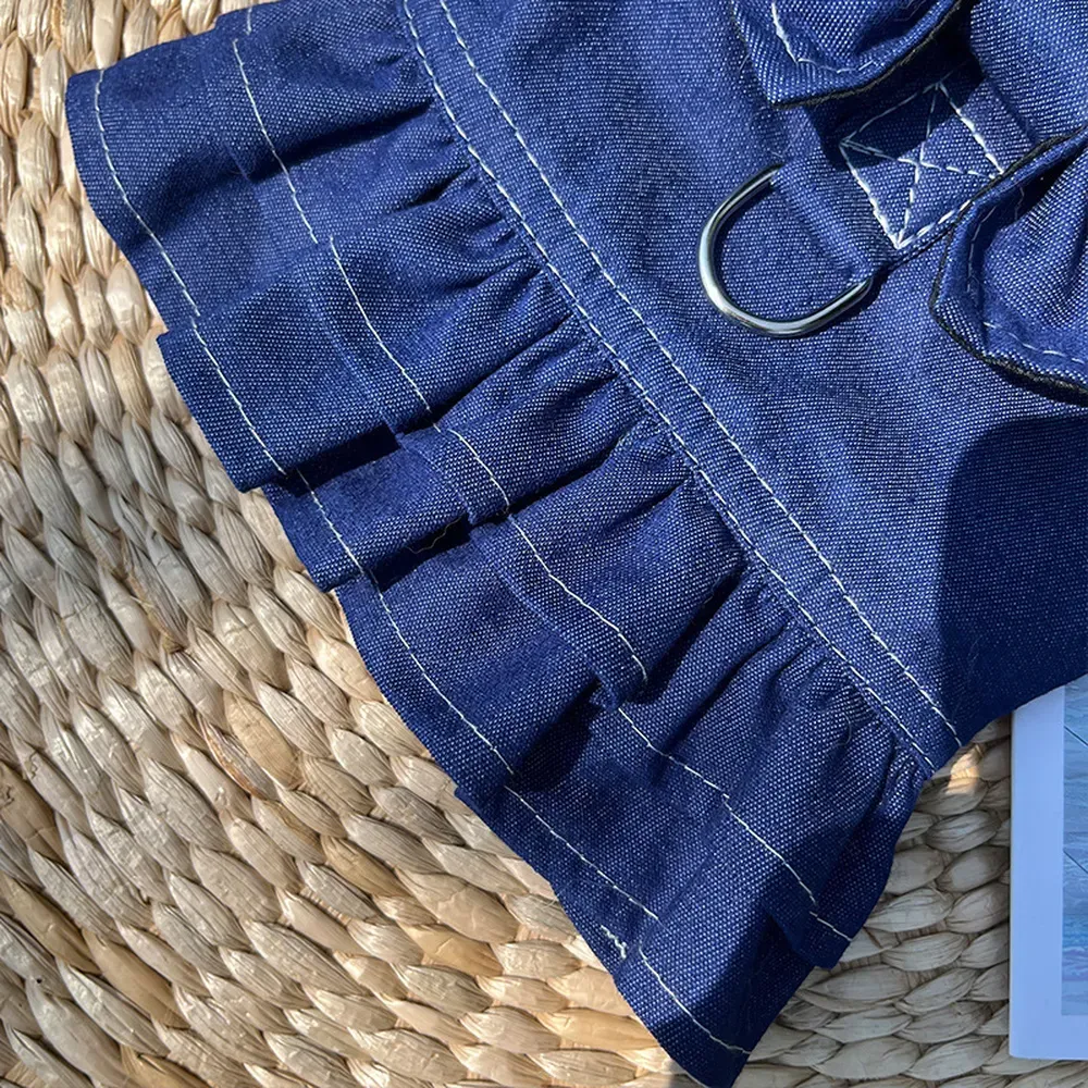 A stylish and functional denim dress with a butterfly bow for small to medium pets, featuring a built-in leash harness with a D-ring for secure leash attachment during walks.
