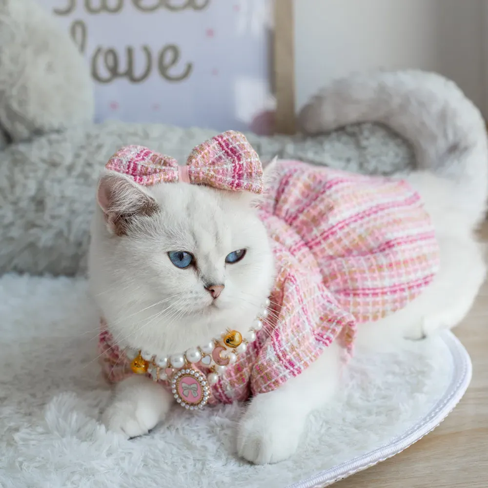 A chic Chanel-style knitted pet coat set, featuring a bow headband, faux pearl necklace, and elegant coat, perfect for adding a touch of luxury and sophistication to pets' wardrobes.