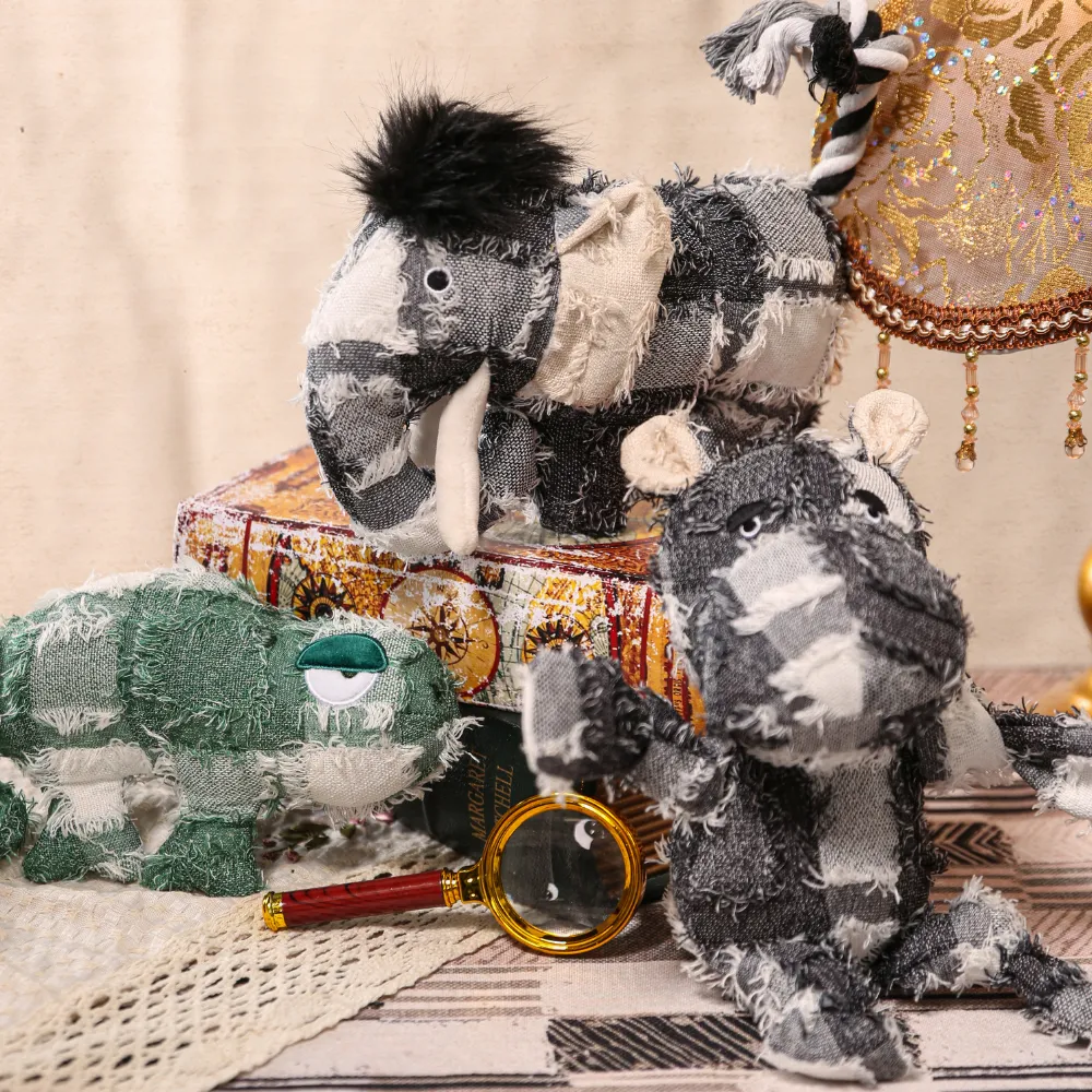 Artistic arrangement of plush toys including a hippo, elephant, and chameleon on vintage books.
