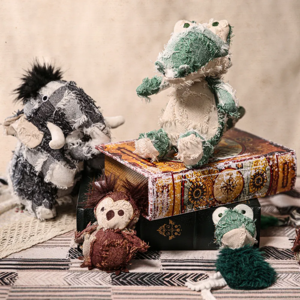 A collection of hippie style plush toys including an alligator and a mammoth displayed on vintage books.