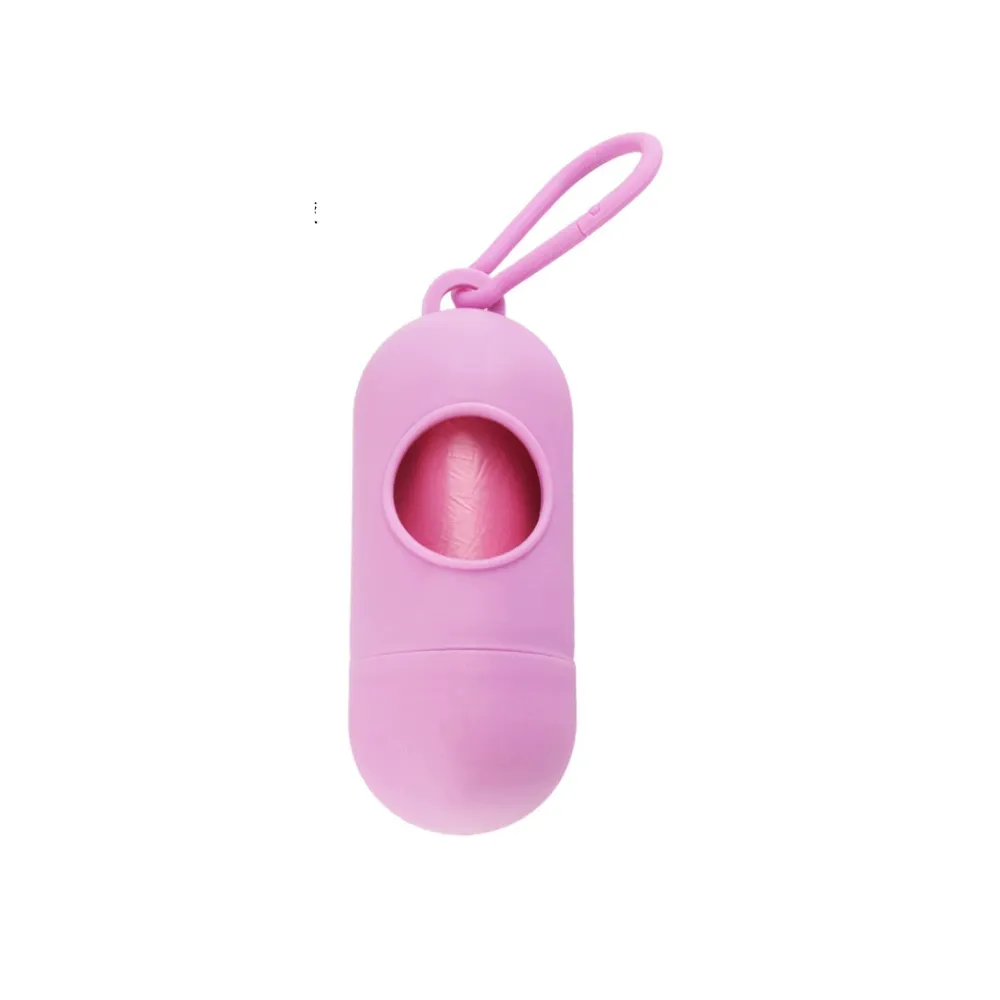 A soft pink pill-shaped dog waste bag dispenser with a matching pink clip and bags.