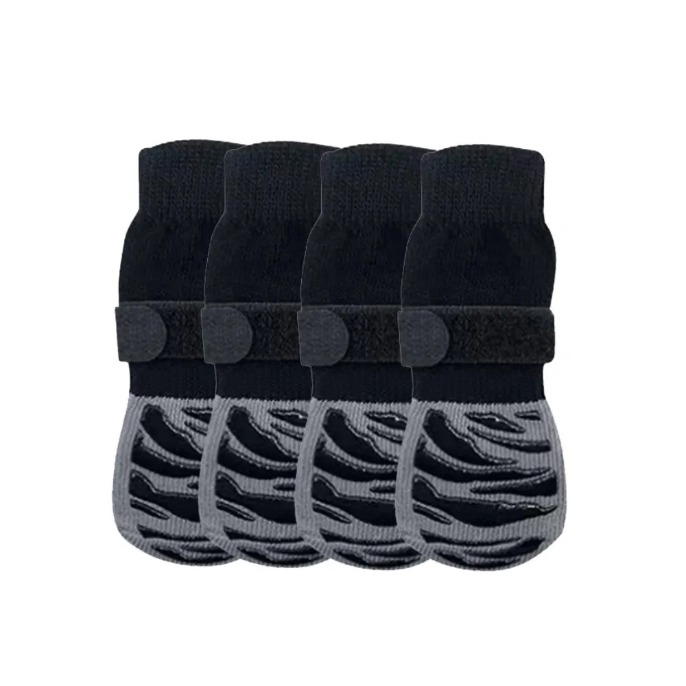 A 4-pack of black and grey striped dog socks with thick rubberized tread and secure adjustable velcro fasteners.