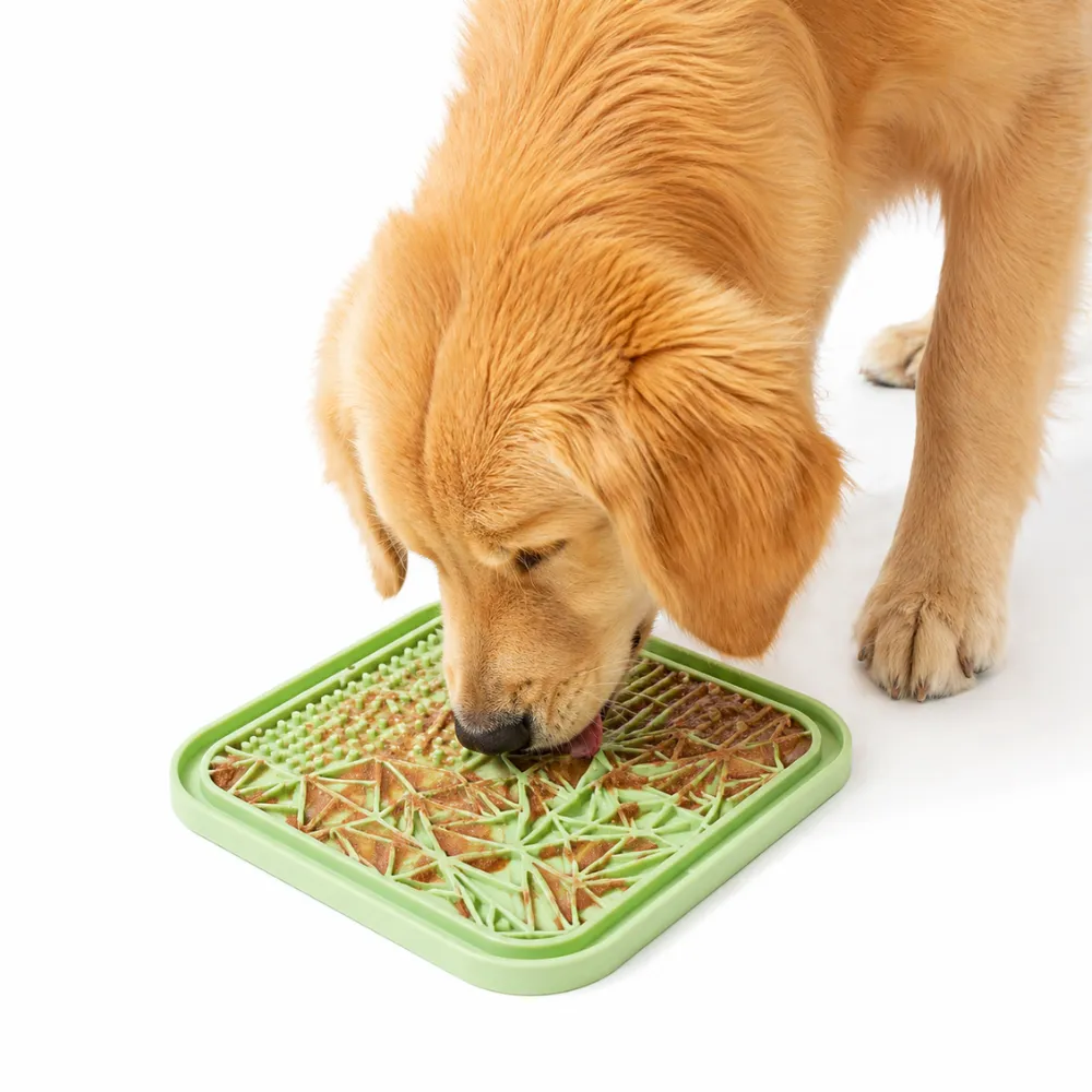 golden-retriever-using-silicone-slow-feeder-lick-mat A Golden Retriever dog licking peanut butter from a green textured silicone slow feeder mat to reduce anxiety and fast eating.