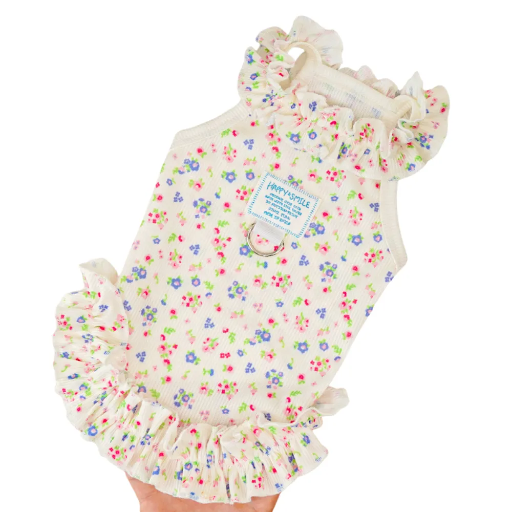 High-angle shot of a lightweight floral print dog dress with purple and pink flowers and a ruffled hem.