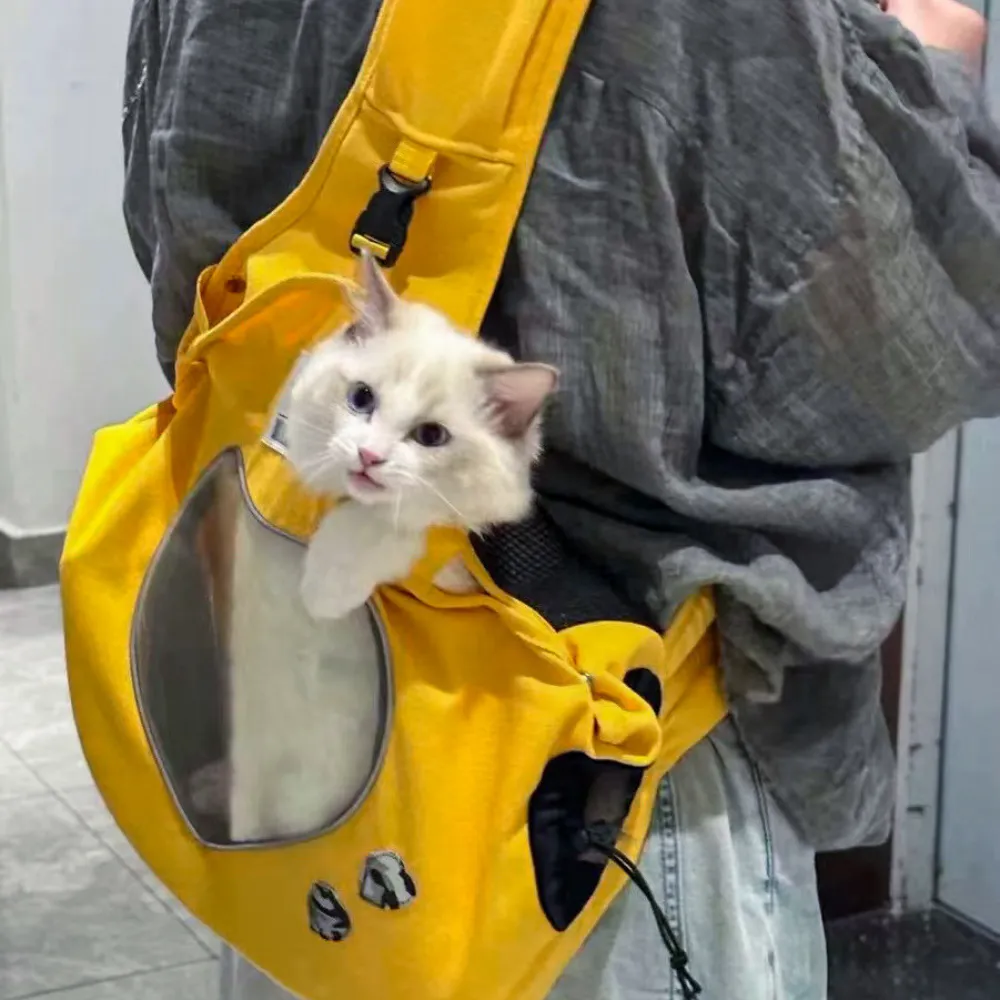 White cat sitting comfortably inside a breathable canvas shoulder carrier bag during travel