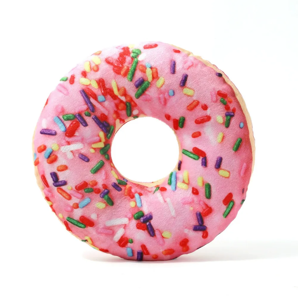 Pink donut plush dog toy with colorful sprinkles on white background