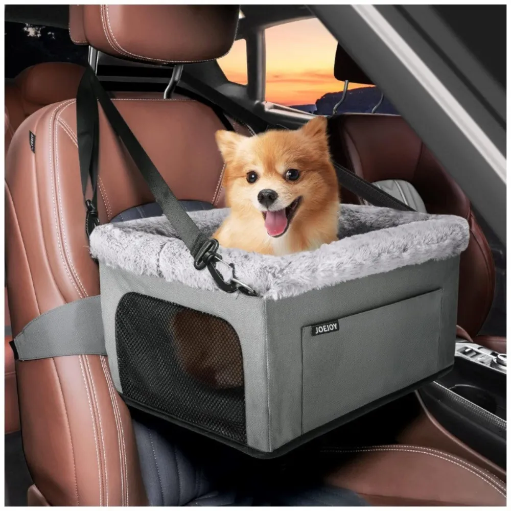Small dog sitting in a gray car booster seat inside a vehicle for safe travel